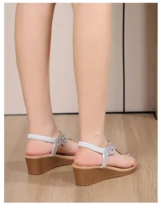 Detail of silver rhinestone flower pattern and elastic heel strap on wedge sandals