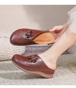 Detail of dark brown cutout mules with floral pattern and thick cushioned sole