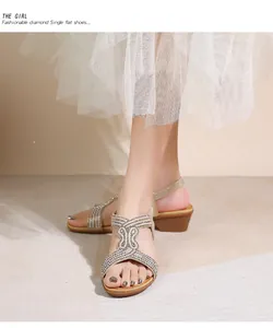 Dettaglio di sandali con zeppa bohémien con decorazioni in strass e cinturini incrociati