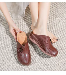 Detail of hollow out flower patterns and 3D floral accents on dark brown wedge mules