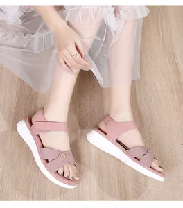 Detail of pink platform sandals with bohemian criss-cross straps and golden ornament