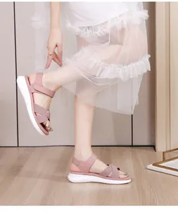Detail shot of pink cross-strap sandals with white platform sole and wavy texture grip