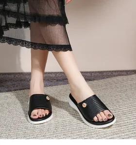 Detail von flachen Bohemian Sandalen mit schwarzen Riemen und goldener Schnalle