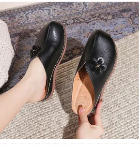 Detail of hollow laser-cut leather mules with 3D floral accent and breathable soft insole