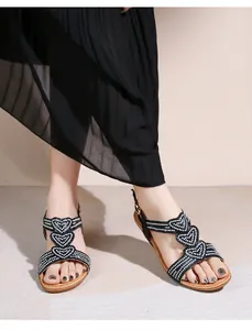 Detail der Bohème-Sandalen in Schwarz mit Herz-Strasssteinen und Sohle in Holzoptik