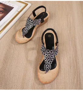 Close-up of black bohemian wedge sandals with sparkling rhinestones and elastic strap
