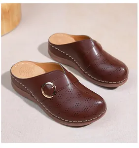 Détails de mules marron à plateforme avec découpes, boucle en métal et surpiqûres blanches