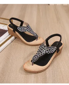 Detail of bohemian wedge sandals with rhinestone butterfly T-strap on wooden footbed
