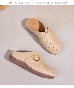Détails de mules beiges ajourées avec anneau doré et semelle compensée surpiquée