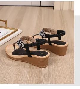 Detail view of Bohemian wedge sandals featuring rhinestone flower straps and elastic heel