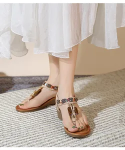 Detail view of bohemian wedge sandals with colorful beads and floral metallic accents