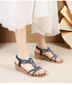 Detail of wedge sandals with navy straps featuring sparkling rhinestones and blue gemstones