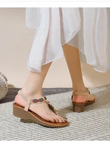 Detail of bohemian wedge sandals with colorful beads and floral accents on apricot straps