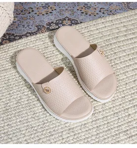 Nahaufnahme der Bohemian-Plateausandalen mit geprägten Riemen und goldener Blumenschnalle