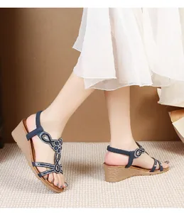 Side view of bohemian wedge sandals featuring sparkling rhinestones and navy blue straps