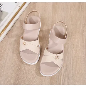 Detail of bohemian beige criss-cross sandals with metallic buckle and white sole