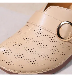 Gros plan sur les chaussures en cuir beige ajouré avec une boucle dorée élégante