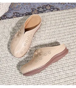 Detail of beige cutout mule sandals featuring triple-layered 3D flower and thick wedge sole