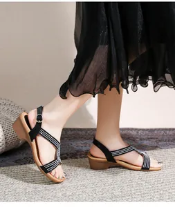 Détail de sandales compensées bohèmes avec lanières croisées en strass et boucle réglable