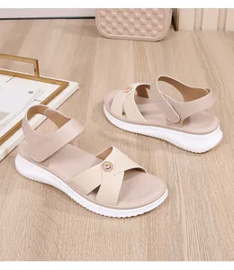 Close-up of beige platform sandals with cross straps and pearl metal buckle detail