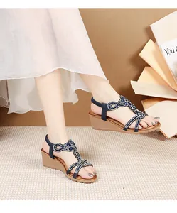 Side view of dark blue platform wedge sandals with sparkling butterfly rhinestone details