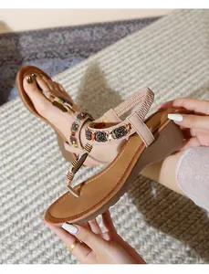 Detail of bohemian wedge sandals with colorful beads and metallic rings on T-strap