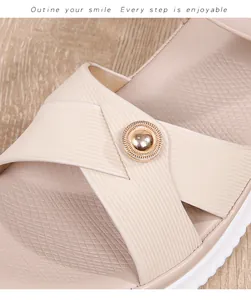 Detail of bohemian flat sandals with textured cross straps and golden metal stud buckle
