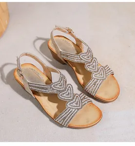 Detail von Boho-Keilsandaletten mit Strassherzen und T-Riemen aus Perlenverzierung