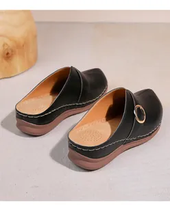 Détail de la tige en cuir noir ajouré avec coutures contrastées et boucle métallique dorée