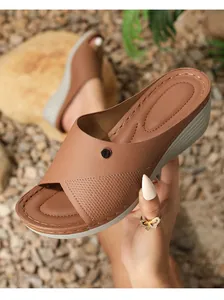 Detail view of brown wedge mule featuring diamond-patterned faux leather and metal buckle