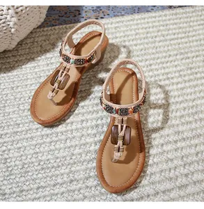 Detail of T-strap bohemian wedge sandal with wooden beads and ethnic embroidery decoration