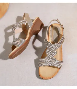 Detailansicht der Keilsandalen mit herzförmigen Perlen- und Strasssteindekorationen