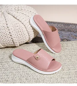 Nahaufnahme von rosa Sandalen mit goldener Blütenschnalle und rutschfester weißer Sohle