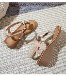Detail of bohemian wedge sandals with intricate beadwork and turquoise metallic accents