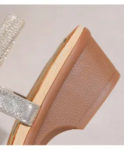 Dettaglio sandalo boho con zeppa, cinturini glitter argento e tacco con stampa a serpente