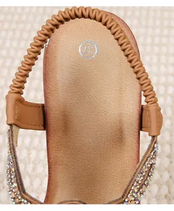 Close-up of bohemian wedge sandals featuring rhinestone trim and elastic heel strap