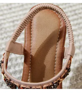 Detail of bohemian wedge sandals with elastic heel strap and vintage beaded decoration