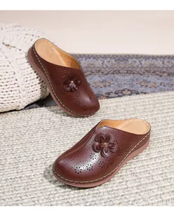 Detail of dark brown mules with hollow flower pattern and sturdy non-slip wedge soles