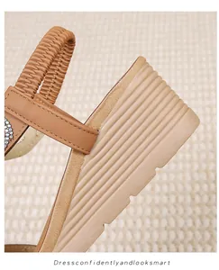 Macro detail of brown wedge sandals featuring elastic straps and rhinestone accents