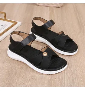 Detail of black cross-strap sandals with gold metal ring and white platform sole