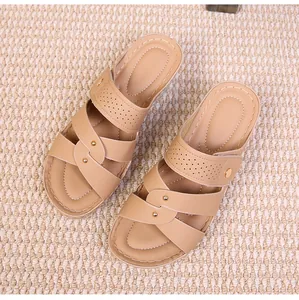 Top view of beige platform wedge sandals with perforated leather straps and golden rivets