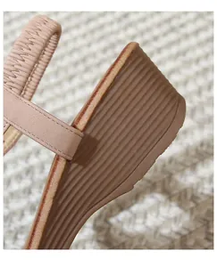 Detail shot of bohemian wedge sandal featuring elastic heel strap and textured sole