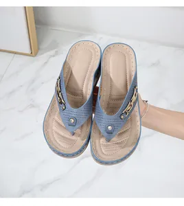 Detail of blue thong sandals with metal chain buckle and sparkling rhinestone decor