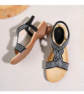 Vista dettagliata di sandali con zeppa boho con strass scintillanti e suola effetto legno
