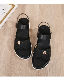 Detail of black wedge sandals with golden metal buckle and white serrated platform sole