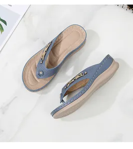 Close-up of summer wedge flip-flops with gold chain, rhinestones and laser-cut detail