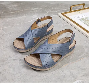 Detail of blue wedge sandals featuring breathable laser-cut straps and ergonomic footbed