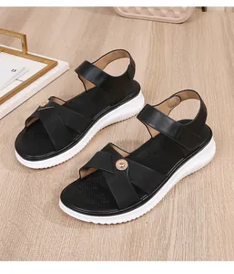 Detail of black bohemian sandals featuring elastic straps and a textured white platform sole