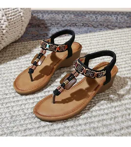 Close-up of bohemian wedge sandals with ethnic beadwork and floral accents on woven mats