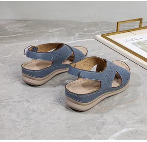 Detail of blue wedge sandals featuring laser-cut hollow patterns and thick white soles